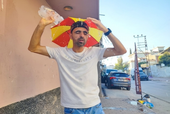 Kafasna takt emsiye ile geziyor